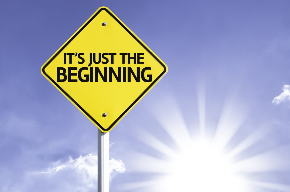 Its Just The Beginning road sign with sun background